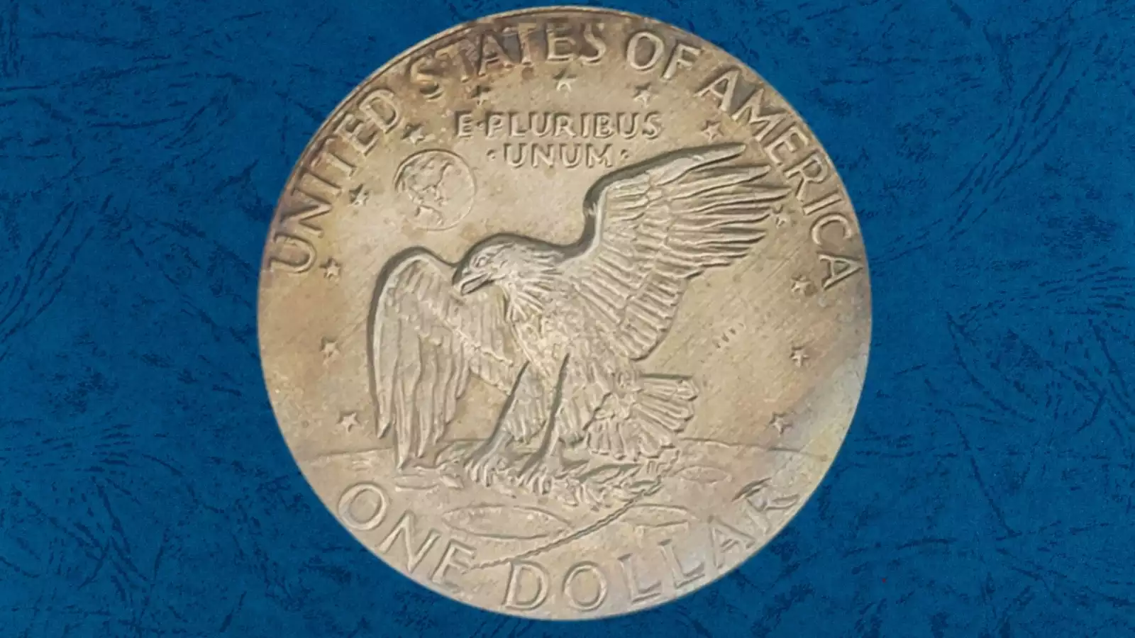 1977 Eisenhower dollar off-center strike error showing design shifted to one side with a blank unstruck crescent area visible
